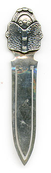 This bookmark was manufactured in Sweden. It is marked with the Swedish state marks and 830S. It has a figural girl reading a book on top. The date is 1930 - 1940.