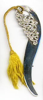 This bookmark was made in the US by Unger Bros. It is marked with the makers hallmark of an intertwined U and B surrounded by sterling 925 fine. It is an art nouveau shape with a yellow silk tassel. The date is 1900 - 1910.