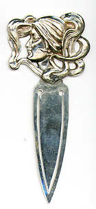 This bookmark was made in the US by William Kerr. It is unmarked because the blades have been replaced. The top is a figural lady head with flowing strands of hair. The date is 1900 - 1910.