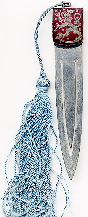 This bookmark was made by an unknown manufacturer possibly in Finland. It has a shield of silver and red enamel with a figural lion. The top has a blue silk tassel. The date is 1920 - 1930.