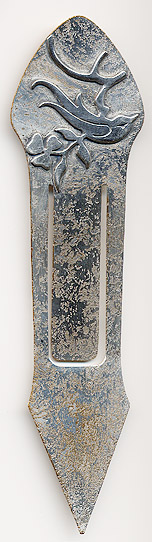 This bookmark was made in the US by the Heintz Art Metal Shop. It is unmarked. The top is a sterling bird on a branch. The bookmark is bronze with a florentine silver finish. The date is 1910 - 1920.