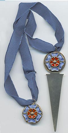  This bookmark was made in Norway. It is marked with N and 925S indicating sterling. It has two silver and enamel flowers connected by a blue silk ribbon. The date is 1950 - 1960.  