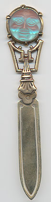  This bookmark was made in Europe, possibly France. The top is a medallion made of saphiret glass in the shape of a moon face caricature. It is a brass bookmark with a dore finish. 