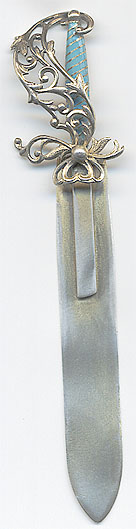 This bookmark was made in the US by H.H. Curtis, Inc. It is marked with the manufacturers hallmark, sterling and the number 700. The back in inscribed "Philopena". It is in the shape of a sword with a blue enamel grip and a fancy flowery hilt. It was once finished in a gold wash. The date is 1890 - 1910.