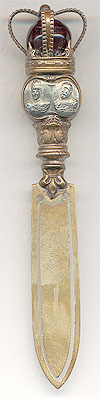  This bookmark was made in Europe by an unknown manufacturer. It is a gilt bookmark produced to commemorative the coronation of Edward VII and Queen Alexandra in 1902. It has gold over brass blades, with engravings of the heads of the king and queen in silver, and topped with crown and center red marble. The date is 1902 - 1910. 