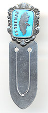 This bookmark was made in Denmark by Meka. It is marked Meka Sterling Denmark on the back. The top is a rectangular medallion surrounded by flowery motif. The medallion is a picture of the island of St. Thomas in the Virgin Islands in a blue enamel. The date is 1930 - 1960.