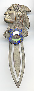  This bookmark was made in the US as a souvenir for Plymouth Rock. It is made of brass in the shape of an Indian head. Under the head is a shield in enamel with a picture of Plymouth Rock. The date is 1940 - 1950.  