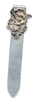 This bookmark was made in the US by an unknown manufacturer. It is marked sterling on the back. It is a small piece with an art nouveau design of a cherub as the top blade. The date is 1900 - 1910.
