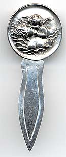  This bookmark was made in the US, possibly by Unger Bros. although it is only marked sterling. The top is a high relief picture of a cherub kissing a young man in the water.  The date is 1900 - 1910.   