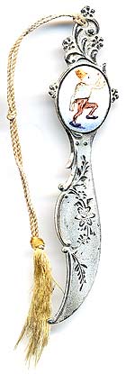  This bookmark was made in the US by an unknown manufacturer. It is marked sterling on the back. The top has an enamel picture of a clown or a monkey dressed as a clown.  The date is 1900 - 1910.   