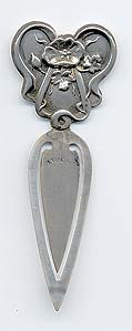  This bookmark was made in the US by an unknown manufacturer. It is marked sterling on the back. The top is an art nouveau design of a flower.    
