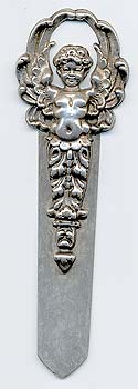  This bookmark was made in the US by an unknown manufacturer. It is unmarked and is either silver or peweter. The top is a winged cherub which extends down to become the top blade. The date is unknown.     
