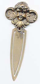  This bookmark was made in the US by William Kerr. It is marked sterling 7 on the back. The top is the face of a cherub and the entire bookmark is finished in a gold wash. The date is 1900 - 1910.     