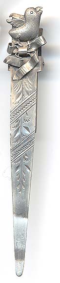  This bookmark was made in the US by an unknown manufacturer. It is marked sterling on the back. This is a clip type bookmark with a baby chick on top of a ribbon. The back is inscribed 1892.  Date is 1892.   
