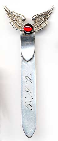  This bookmark was made in the US by Unger Bros. It is marked on the back with the makers hallmark of the intertwined U and B. The top has a pair of wings with a red stone in the center. The date is 1900 - 1910.   