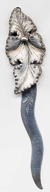  This bookmark was made in the US by an unknown manufacturer. It has an unknown hallmark on the back along with the word sterling. The top blade is a high relief cluster of leaves. The date is 1900 - 1910.  