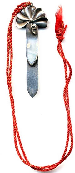 This bookmark is made in the US by an unknown manufacturer. It is marked Solid Silver on the back. The top is a figural flower with a stem and a long red tassel. The date is 1920 - 1950.