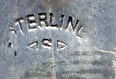 This bookmark was made in the US by E.H.H. Smith Silver Co. It is marked Sterling with the manufacturers mark. The bookmark is a figural of an African American boy with a derby hat. The back is a scene with mountains and trees an it says Ashville, NC. The date is 1904 - 1920.