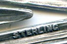 This bookmark was made in the US by an unknown manufacturer. It is marked sterling on the lower outer blade. The top is a rabbit poking his body out of a lily flower. This was most likely an Easter gift. It was sold in the 1910 Shreve catalog. 