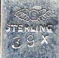 This bookmark was made in the US by Shiebler. It is marked with the Shiebler hallmark, sterling and 39x. The top is some funky design in a different metal, possibly gold.  The date is 1900 - 1910.