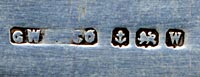This sterling bookmark was made in Birmingham England in 1921 by G W Lewis as indicated by the hallmarks. The top has a glass enclosed piece of a butterfly wing in iridescent blue. It is still quite vibrant after 95+ years.
