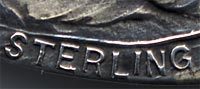 This bookmark was made in the US by Webster Co. It is only marked sterling. It is in the shape of a heart with a picture of a woman in the center. The date is 1913. 