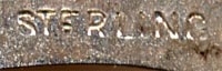This bookmark was made in the US by an unknown manufacturer. It is in the shape of a heart with an inscribed design on the inner blade. The back is marked sterling and has the inscription "E.H. Sep. 10 '98". A red tassel is attached at the top.