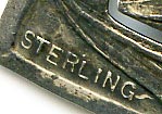 This bookmark was made in the US by Webster Co. It is marked sterling and is in the shape of a heart. The center blade has a picture of a tiger lily flower.