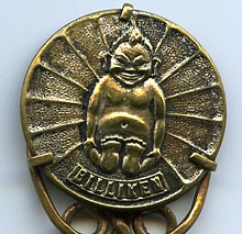 This brass bookmark has a medallion with a Billiken in the center. According to Wikipedia, the Billiken was a charm doll created by an American art teacher and illustrator, Ms. Florence Pretz of Kansas City, Missouri, who is said to have seen the mysterious figure in a dream. In 1908 she patented the Billiken who was elf-like with pointed ears, a mischievous smile, and a tuft a hair on his pointed head. His arms were short and he was generally sitting with his legs stretched out in front of him.