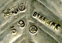 This bookmark was made in the US by Gorham. It is marked with the Gorham hallmark, Sterling, a date mark and number 59. It is in the shape of two leaves and two berries. This is from the Autumn 1888 Gorham catalog where they sold 33 different bookmarks.  