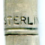 This bookmark was made in the US by Daniel Low and Co. It is comprised of a flat blade connected by chain to a mechanical pencil. It is marked sterling on the top of the pencil and engraved Salem on the blade. The blade also shows the famous Salem witch riding a broom, the trademark of Daniel Low.