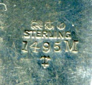 This bookmark was made in the US by Gorham Mfg. Co. It  is marked with the manufacturers hallmark, 1495M and an anchor as the date mark for 1887. The top is lyre surrounded by olive leaves.