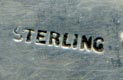 This bookmark was made in the US by an unknown manufacturer. It is hallmarked sterling on the back. It has a very small top blade and a curvy larger one. The top has a cutout flower.