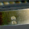 This bookmark was made in France. The top is a magnifying glass held up by two horns of fruit. The top blade has 3 bees (a symbol of Napoleon). It has two French hallmarks on the side of the glass. 