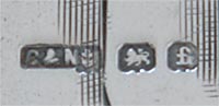 This bookmark was made in Birmingham, England by Chrisford and Norris. it is hallmarked for Birmingham 1905. The bookmark is in the shape of a hand with the index finger pointing down.