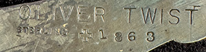 This bookmark was made in the US by J.F. Fradley. It is marked on the back with sterling, the manufacturers hallmark of a cross, the number 7, and Oliver Twist. This is a figure of the Dickens character from the book with the same name. The date is 1890 - 1936.