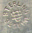 This bookmark is American made by Unger Brothers. The mark is an interlaced U and B. It has an art nouveau flower on top with a plain silver blade. This was the April flower from a set of twelve, one for each month.  