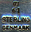This bookmark was made in Denmark by Georg Jensen. It is marked GI, 61, and Sterling Denmark. This is an old mark used before 1920. The bookmark is in the shape of a wreath with the center in the shape of a heart.