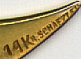 This bookmark was made in the US. It is 14K gold with a lead crystal on top and an opal underneath. It is marked 14K R. Schaezlein. The top blade is finely scribed with an intricate design having a crescent moon and a star. 