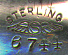 This bookmark was made in the US by Shiebler. It is marked with the famous winged "S" and sterling and 8744. The top blade is a flower with a leaf, stems and buds. The date is 1900 - 1910.