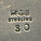 This bookmark was made in the US by Gorham Mfg. Company. It is marked with the manufacturers mark, sterling and 30, the number from the Autumn 1888 catalogue. The top blade is a figural basket of flowers. 