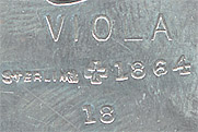  This bookmark was made in the US by J.F. Fradley. It is marked on the back with sterling, the manufacturers hallmark of a cross, the numbers 1864 and 18, and Viola. This is a figure of the Shakespeare character Viola from the play "Twelfth Night." The date is 1890 - 1936.   