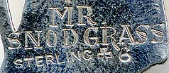  This bookmark was made in the US by J.F. Fradley. It is marked on the back with sterling, the manufacturers hallmark of a cross, the number 6, and Mr. Snodgrass. This is a figure of the Dickens character Mr. Snodgrass, a shady character from the book "The Pickwick Papers" The date is 1890 - 1936.     