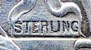  This bookmark is made in the US by Webster. It is only marked sterling. It is in the form of a cross with flowers. The top look normally holds a ribbon with a tassel.    