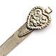 This bookmark was made in the US by an unknown maker. It is marked sterling on the back. The top is an ornate heart shape. The date is early 20th century.