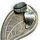 This bookmark was made in El Salvador. It is marked 900 and El Salvador. It is in the shape of a coffee leaf with a coffee bean and another leaf on top.