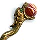 This brass bookmark was made in France by an unknown manufacturer. It is a sea dragon with a banded agate marble in it's mouth. It has green glass eyes and is highly detailed.