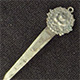 This bookmark was made in the US by an unknown manufacturer. It is marked sterling on the back. The top is a a rose surrounded by a wreath.