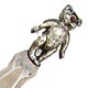 This bookmark was made in the US by Unger Bros. It is marked with the manufacturers mark of an interlaced U and B surrounded by Sterling 925 Fine. It is a figural teddy bear on top with ruby eyes. The date is 1900 - 1910.