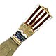 This bookmark was made in Norway. It is marked 830S with a flower symbol and the letter N. It is a front view of a Viking ship with red and white striped sails and blue water. It is finished in a gold wash. The date is 1930 - 1940.
